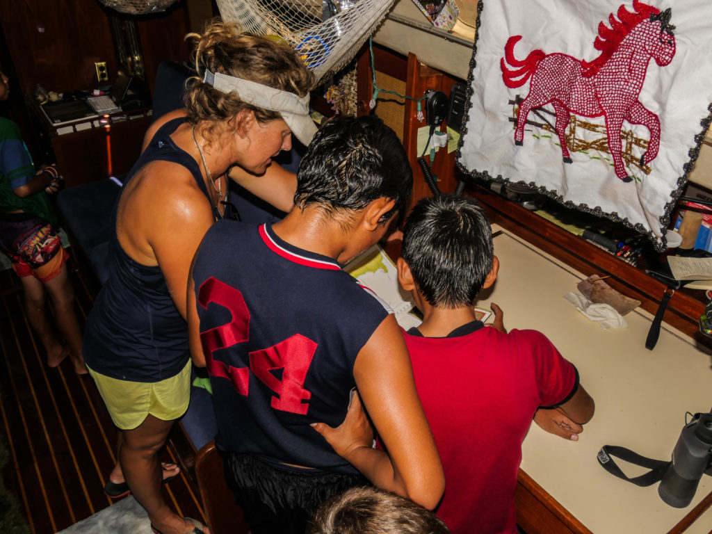 Checking out the guidebook at the chart table. They loved seeing the aerial images of the bays that they know. The napkin with the horse (hanging from the window for shade) was made by one of the Agua Verde school teachers to support the school funds.