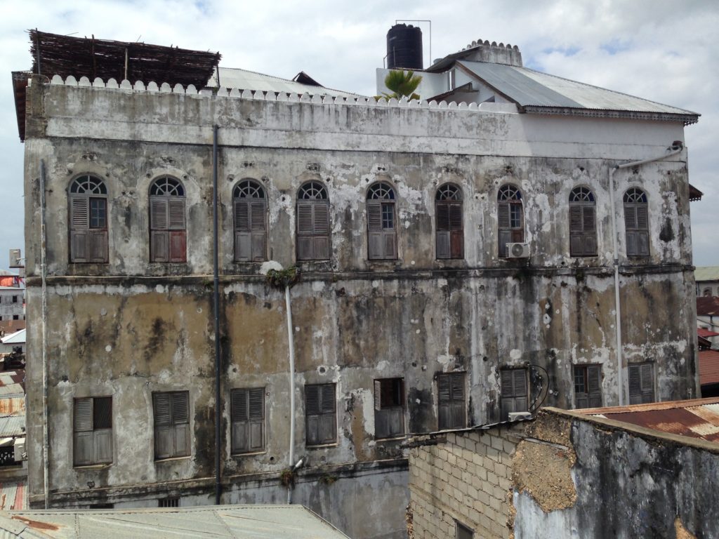An old Omani mansion in Zanzibar that was converted into public housing by the SMZ. The fort-like merlons atop the building are a common Omani architectural motif