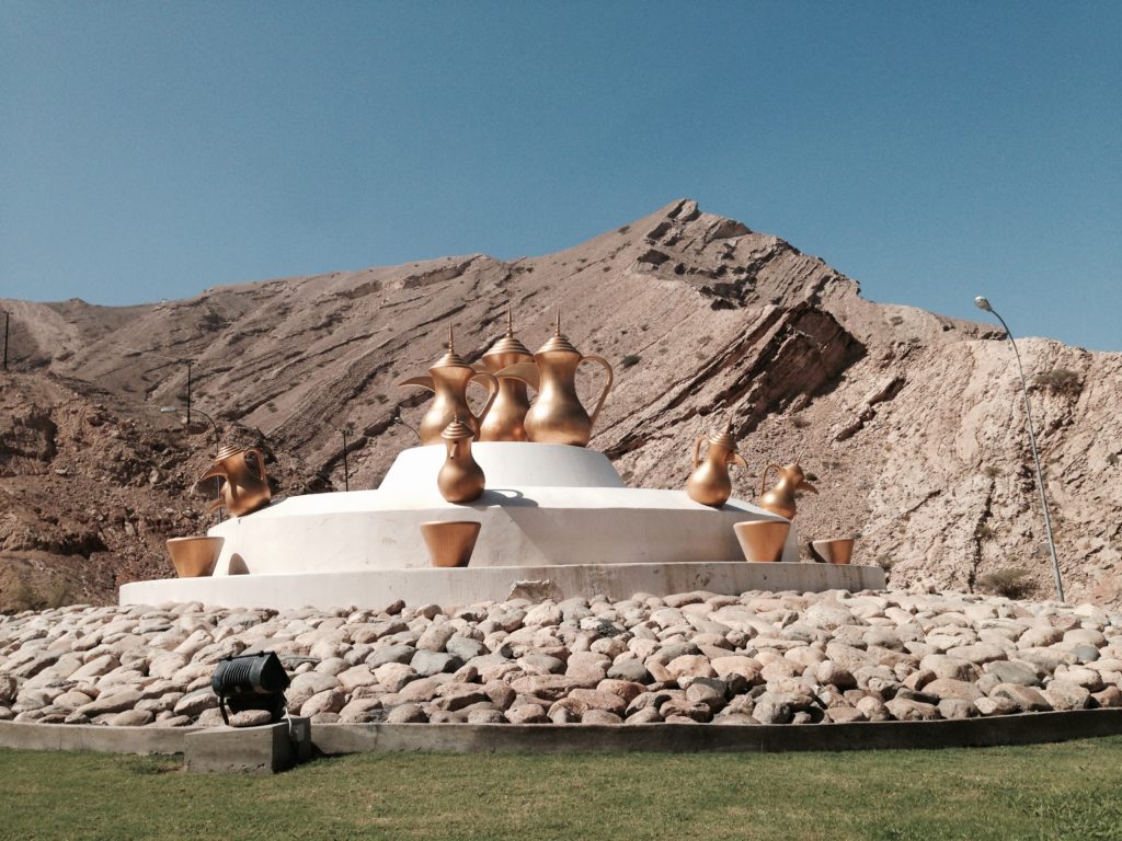 Gold colored dallahs adorn a roundabout in Muscat.