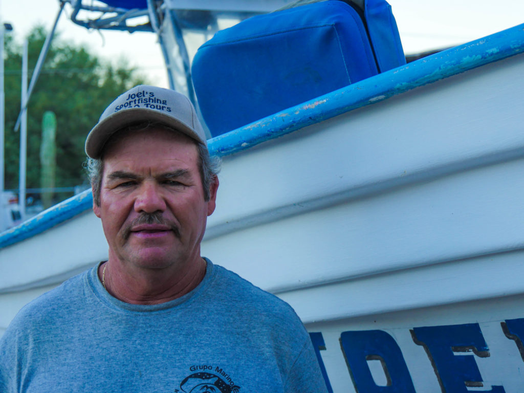 Joel in front of his panga that he uses for educational trips in the Bay.