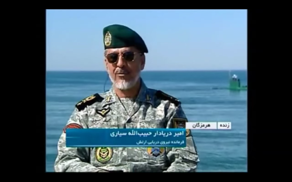Rear Admiral Habibollah Sayyari giving an interview in the Hormozgan province with a submarine in the background. Screenshot courtesy of Islamic Republic of Iran News Network.