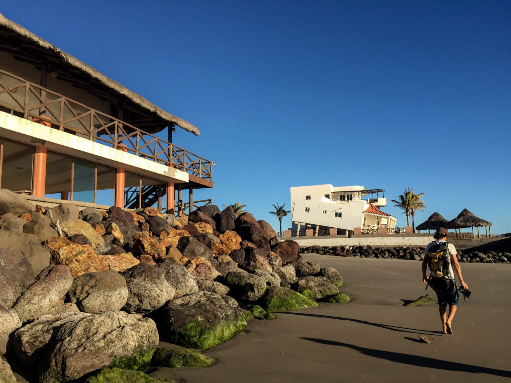 The high tide line beats at the rocks in the house in the foreground. In the distance, an entire house is diving forward on its foundation.