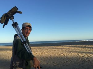 Luis Morales, with his bird spotting scope, tunes into his local birds in the morning’s first sun.