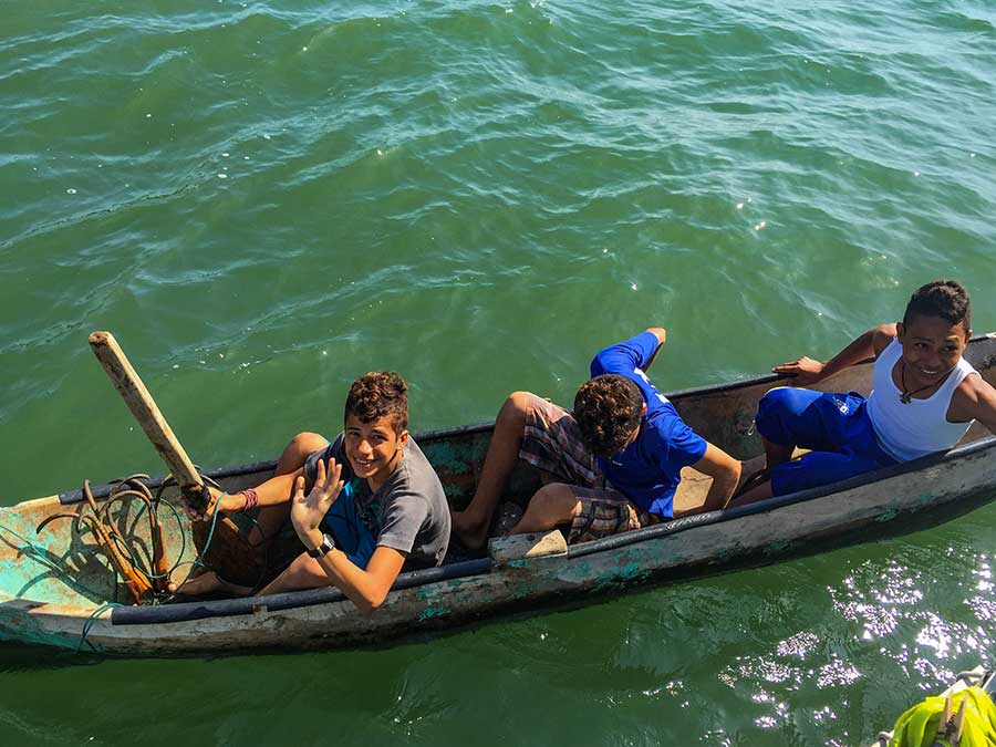 The canoe and paddles are rough, but the three boys make it work—though not without plenty of giggling.