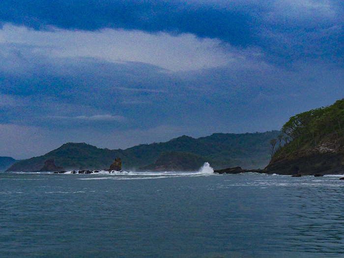 The famous Witch’s Rock in northern Costa Rica, flanked by steep cliffs covered in deep green vegetation.